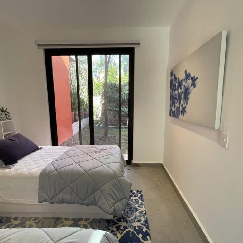 Bright bedroom with large sliding glass door opening to garden.