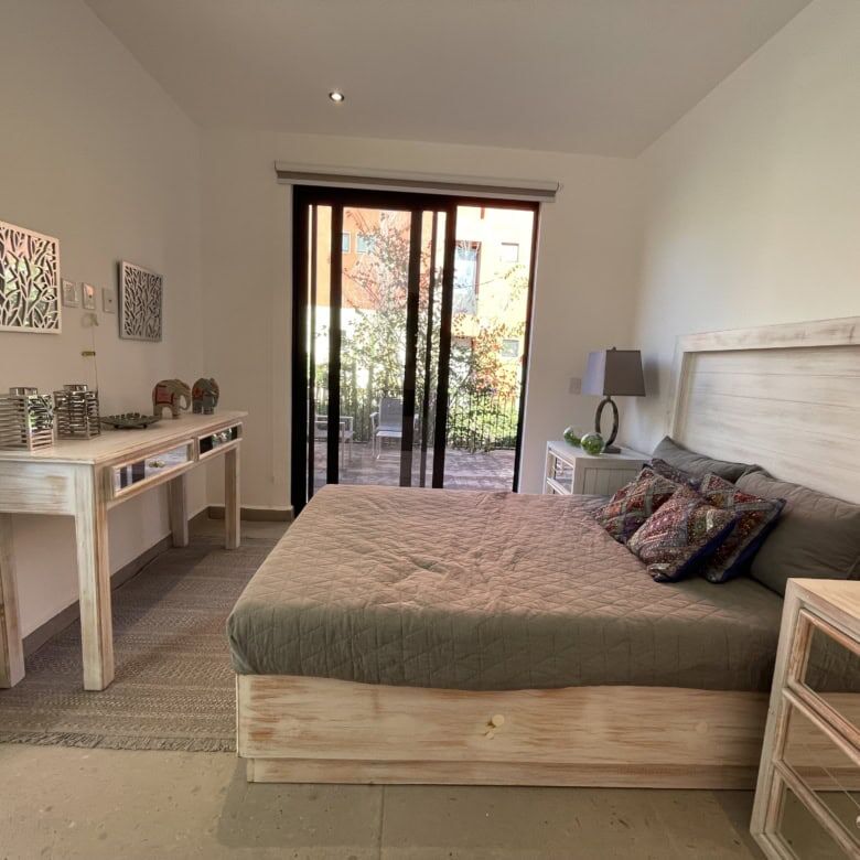 Spacious bedroom featuring a large bed, stylish decor, and access to outdoor terrace.