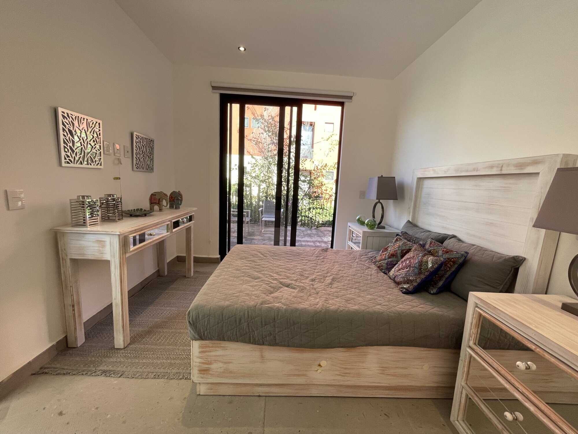 Spacious bedroom featuring a large bed, stylish decor, and access to outdoor terrace.