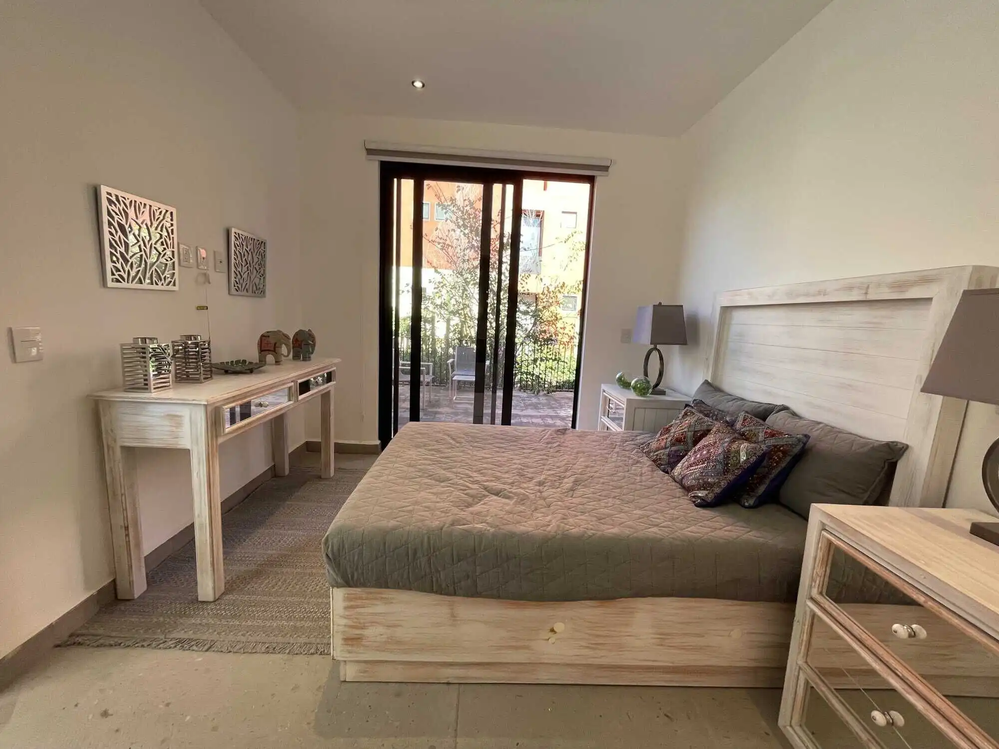 Spacious bedroom featuring a large bed, stylish decor, and access to outdoor terrace.