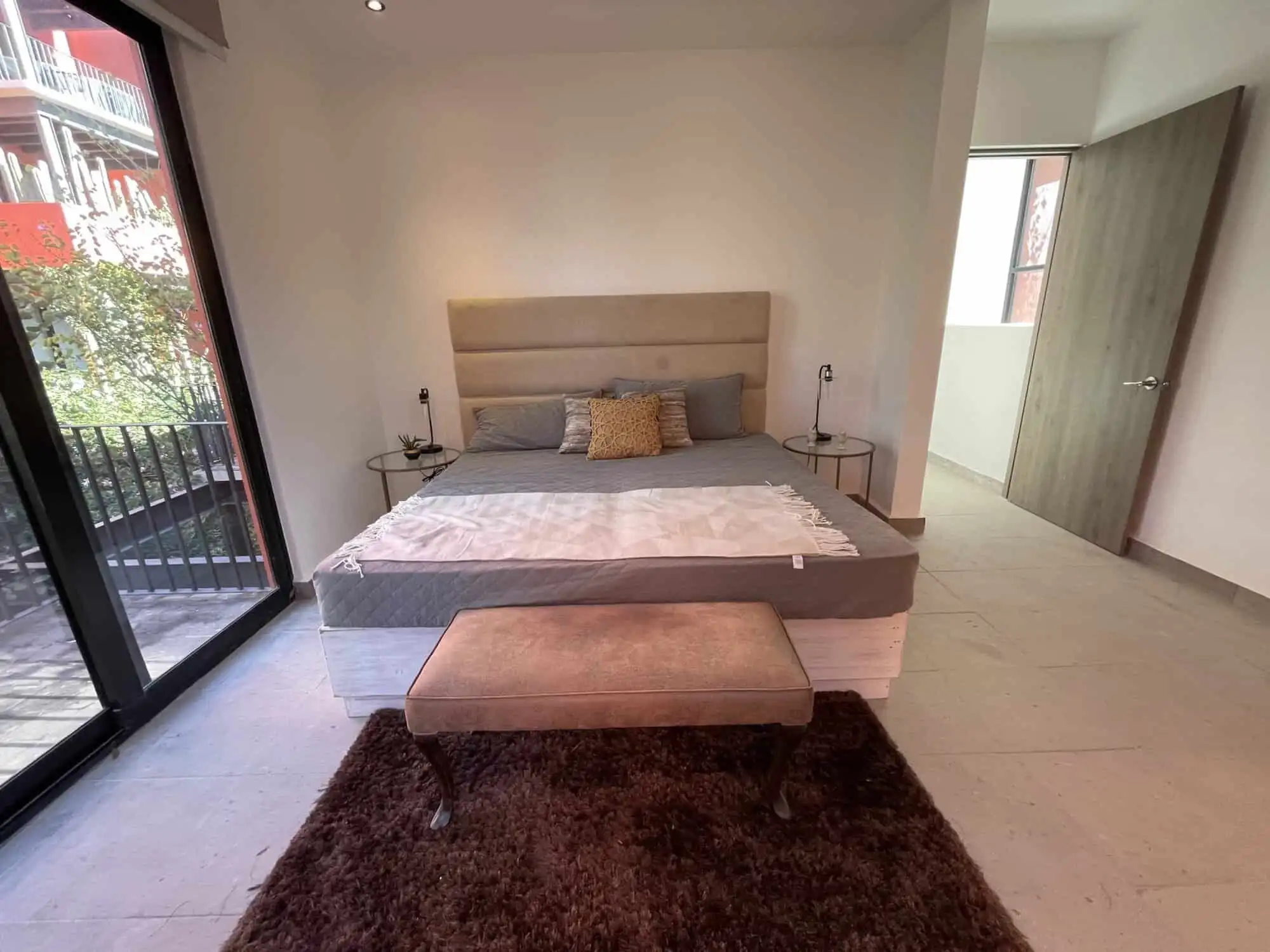 Spacious bedroom with modern decor, large windows, and access to a balcony in Punta de Cielo, San Mi.
