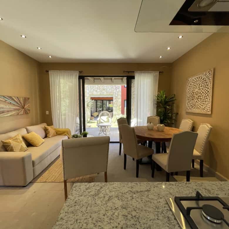 Spacious living room with natural light, stylish decor, and access to outdoor patio. Perfect for com.