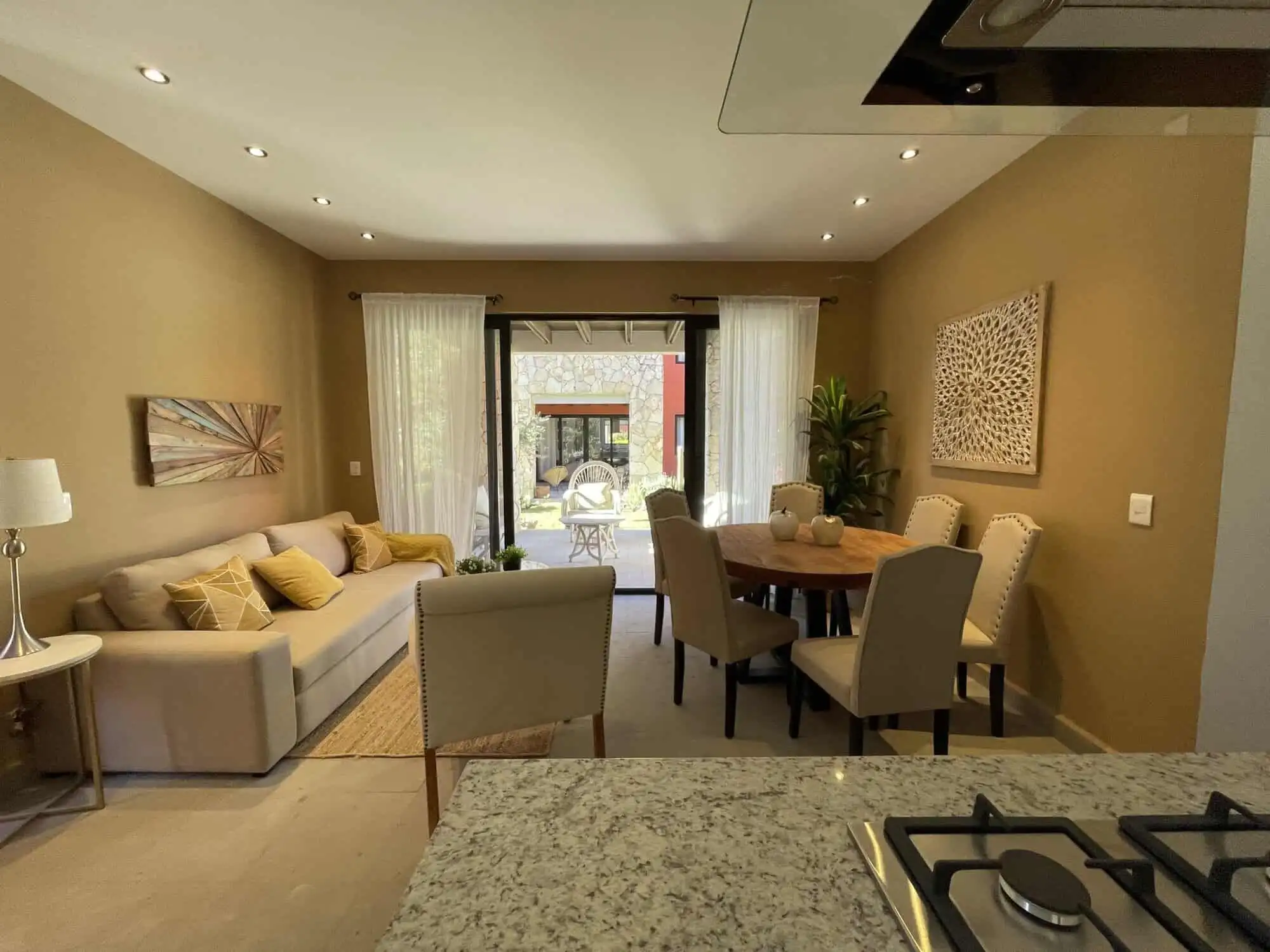 Spacious living room with natural light, stylish decor, and access to outdoor patio. Perfect for com.