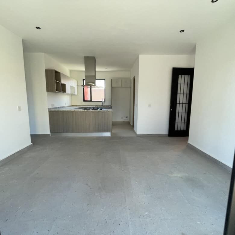 Spacious interior of a penthouse condo featuring a contemporary kitchen and bright living area.