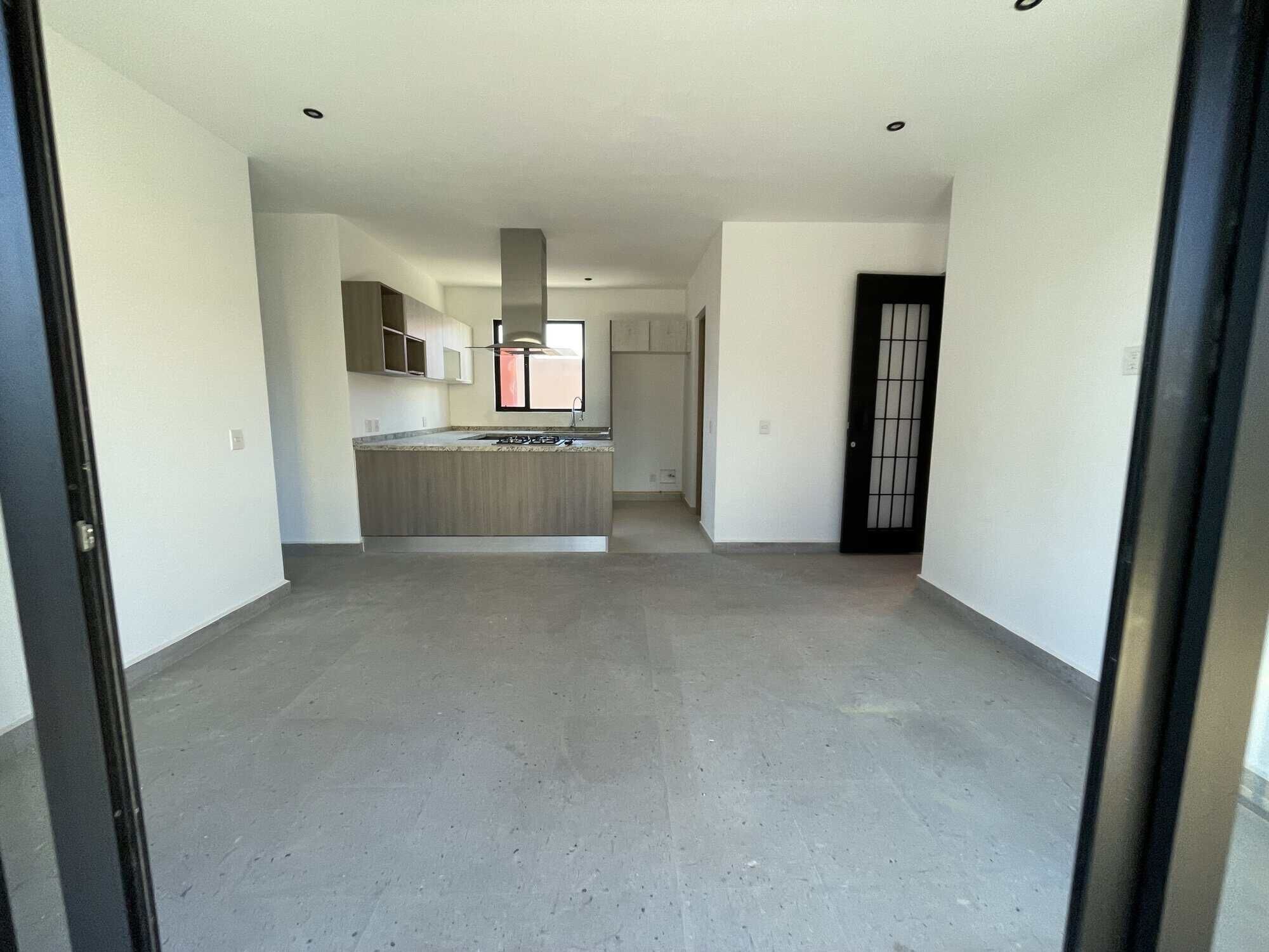 Spacious interior of a penthouse condo featuring a contemporary kitchen and bright living area.