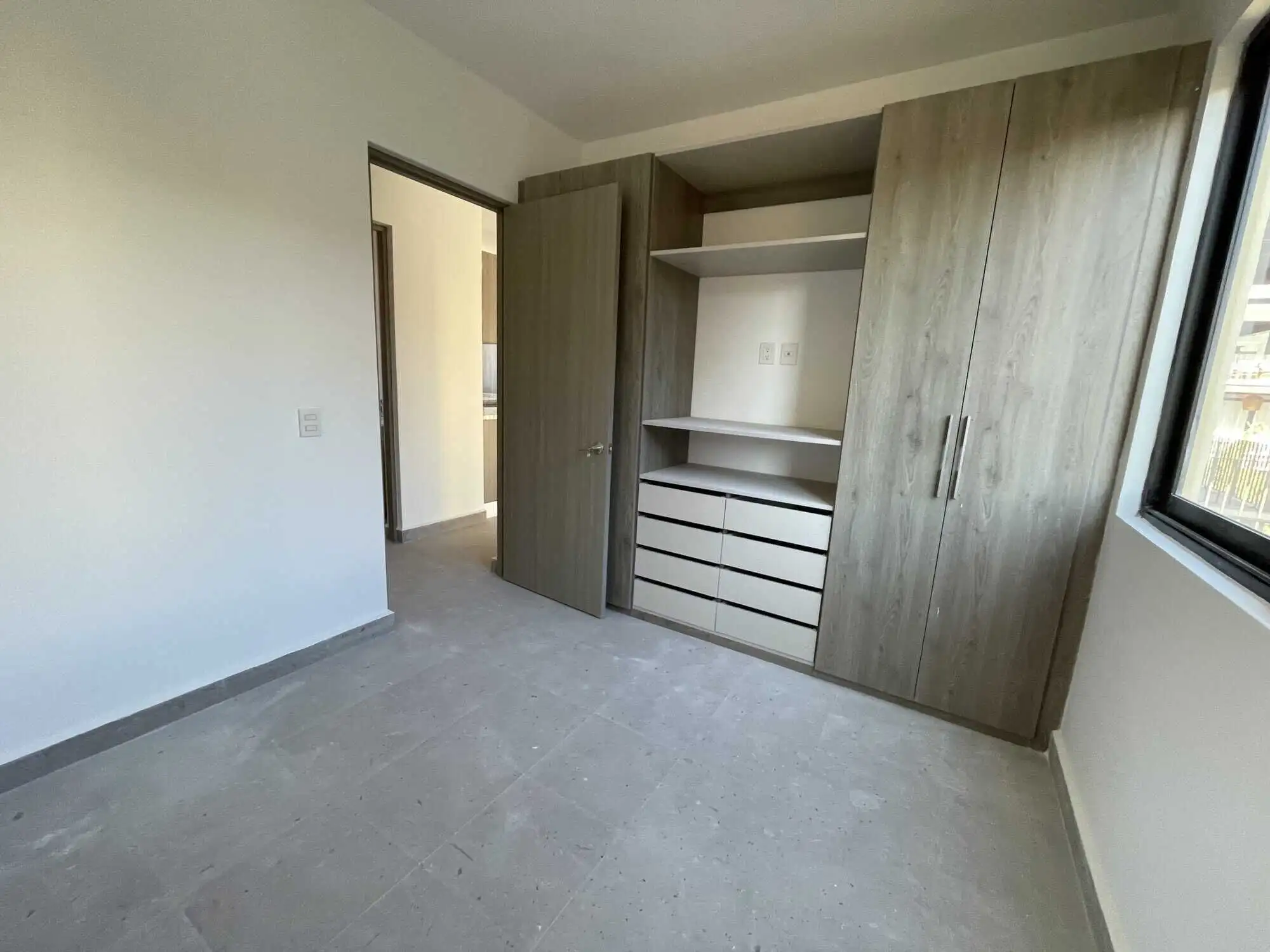 Modern bedroom with built-in closet in San Miguel de Allende. Spacious bedroom featuring a sleek built-in wardrobe and ample natural light.