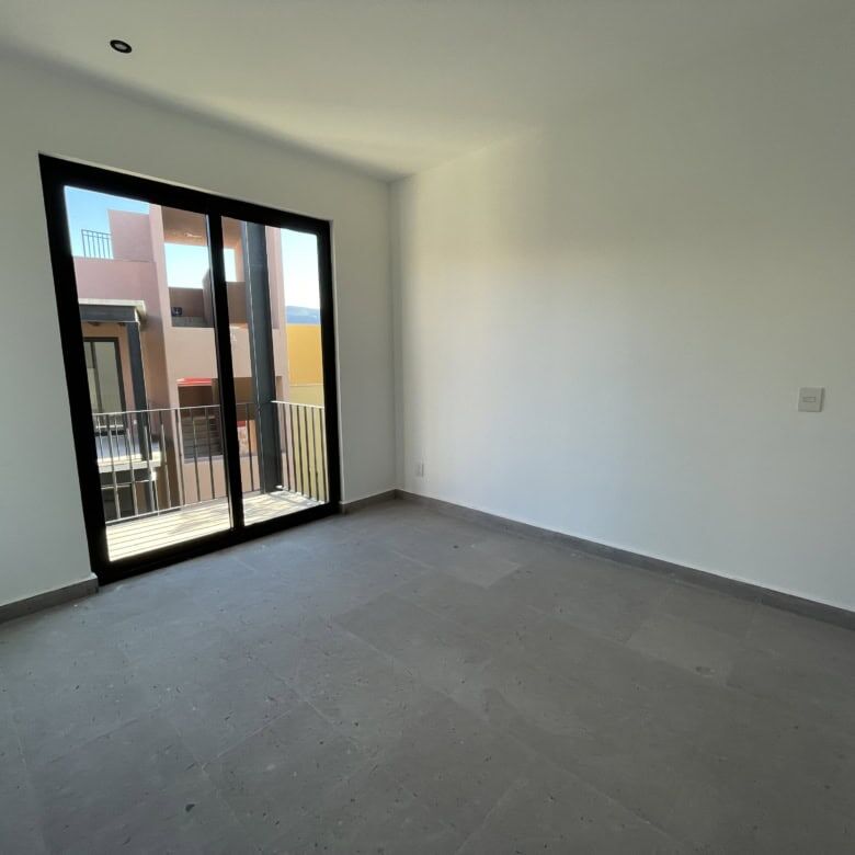 Spacious interior with large sliding glass doors opening to a balcony in a penthouse condo.