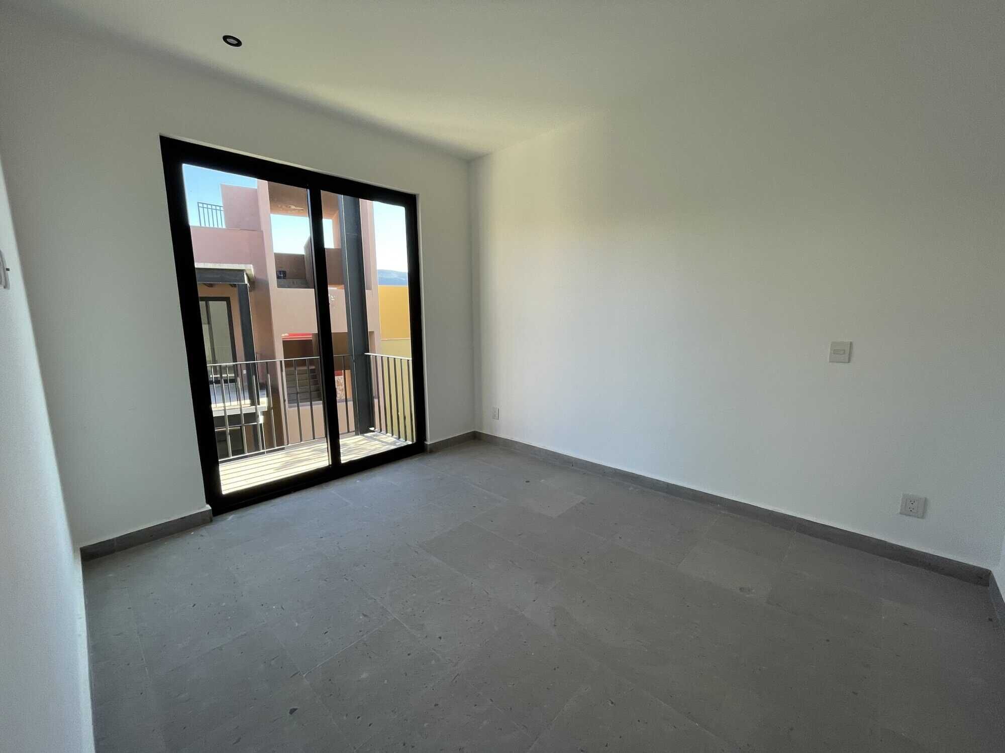 Spacious interior with large sliding glass doors opening to a balcony in a penthouse condo.