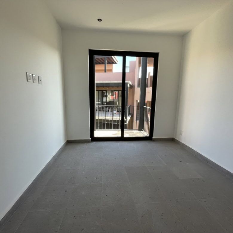 Modern interior room with balcony access in a penthouse condo.