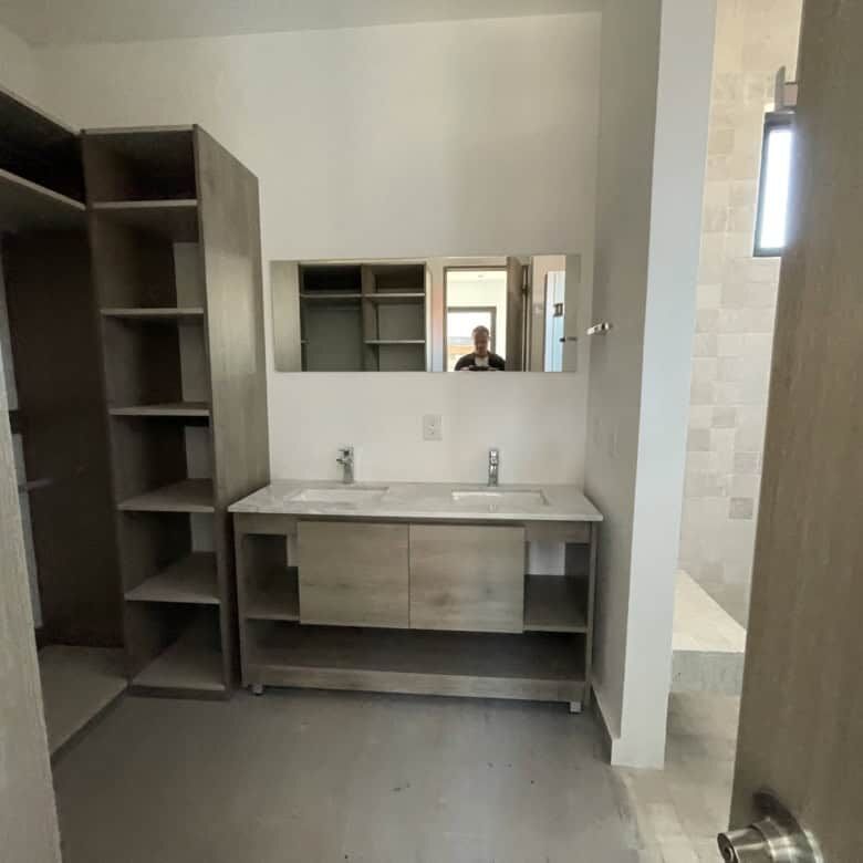 Modern bathroom in penthouse condo with dual sinks and stylish cabinetry.