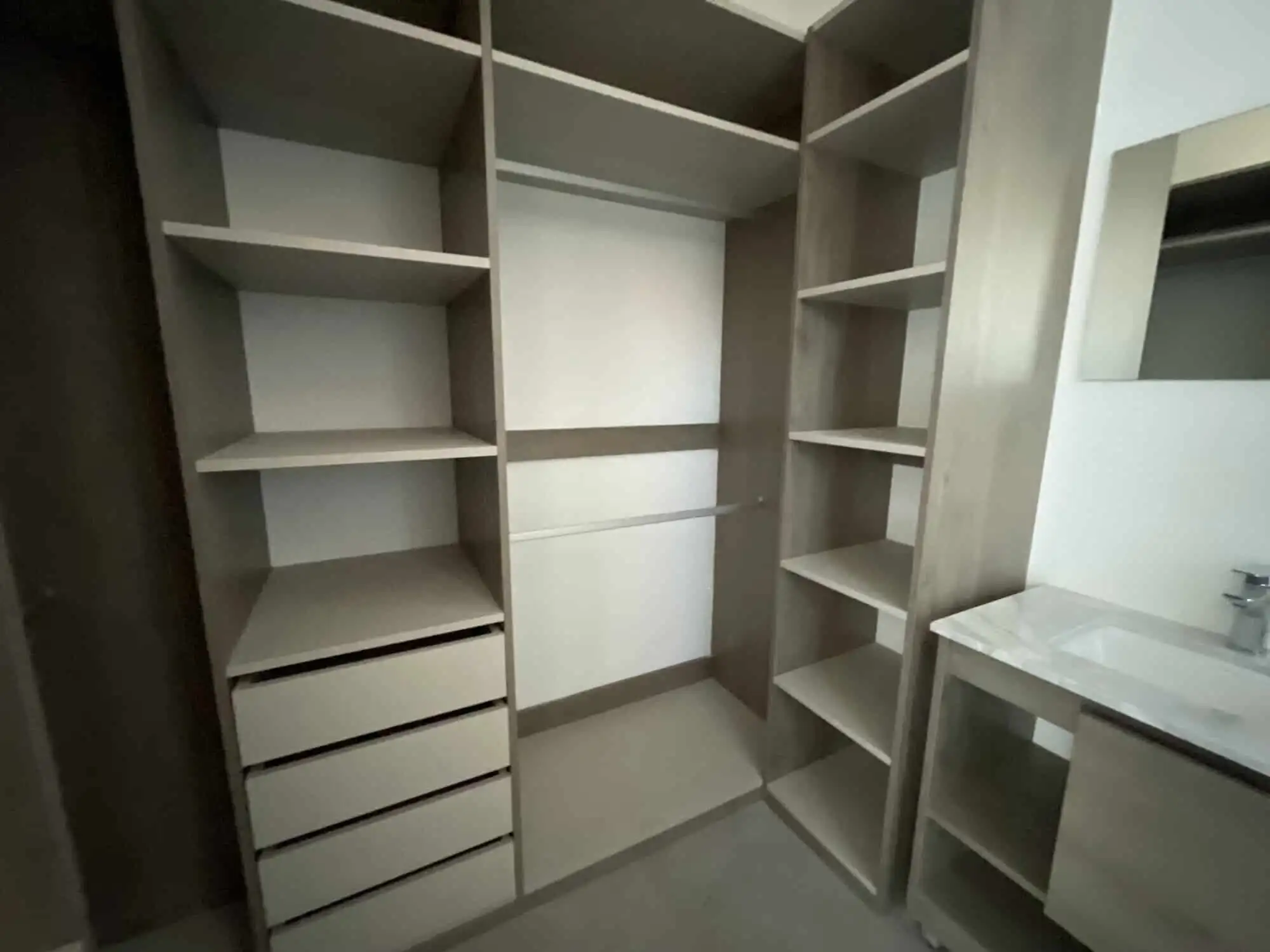 in closet with ample storage space and built-in drawers In closet with multiple shelves and drawers for organized storage.