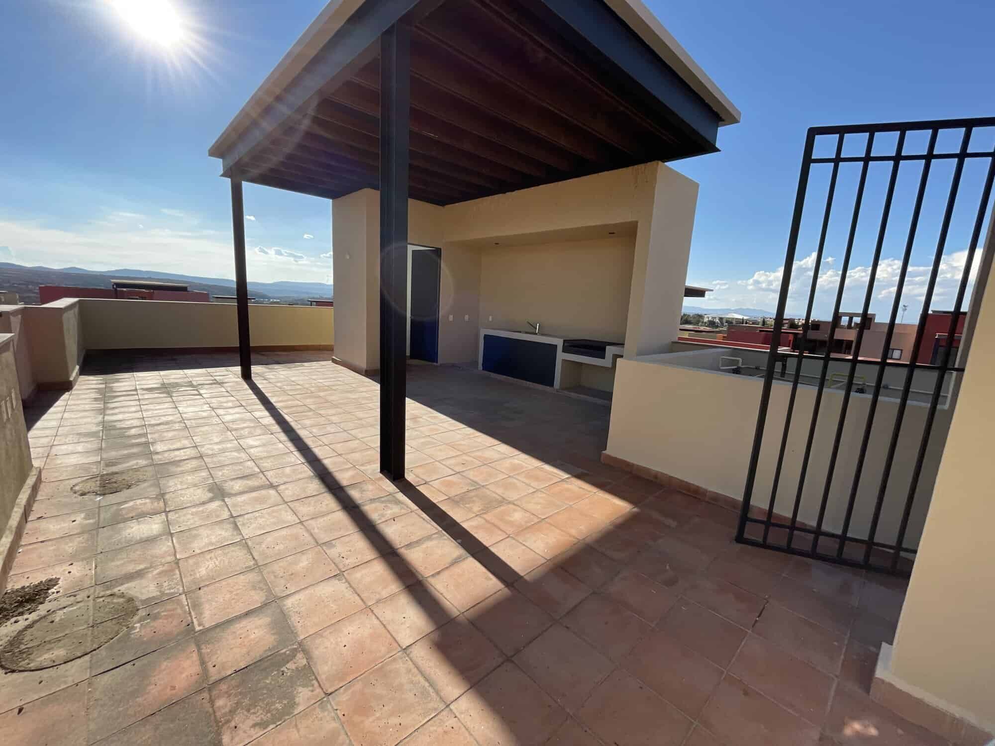 Rooftop terrace of a penthouse condo with shaded area and city views in San Miguel de Allende.