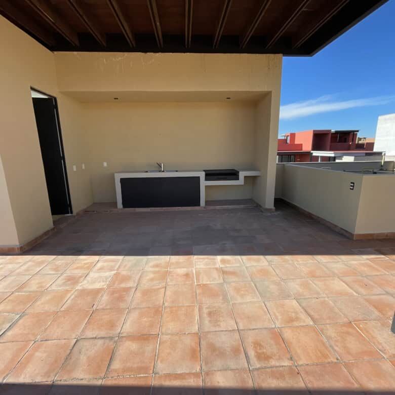 Rooftop terrace with outdoor kitchen in a penthouse condo, offering stunning city views in San Migue.