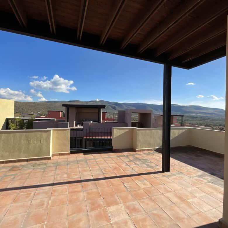Spacious rooftop terrace of a penthouse condo in San Miguel de Allende with scenic mountain views.