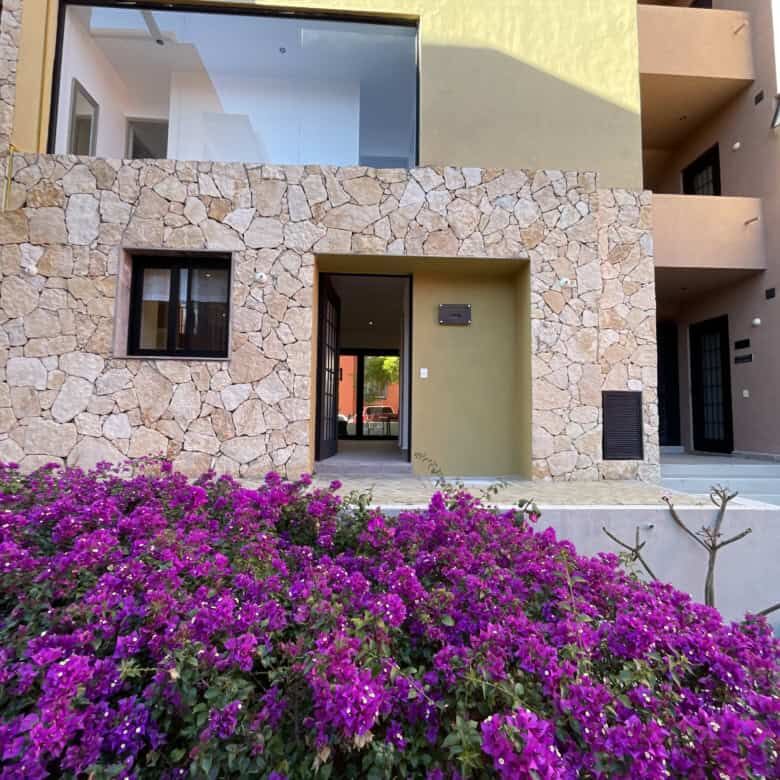 Modern stone exterior home with large glass windows in San Miguel de Allende.