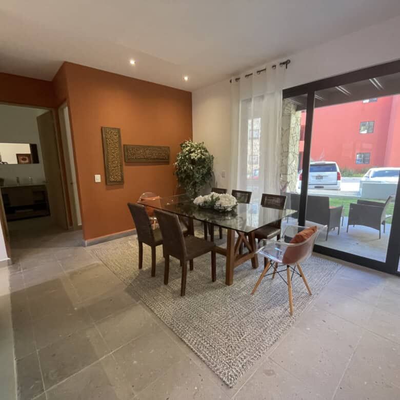 Spacious interior featuring a wooden dining table, six chairs, and natural light.