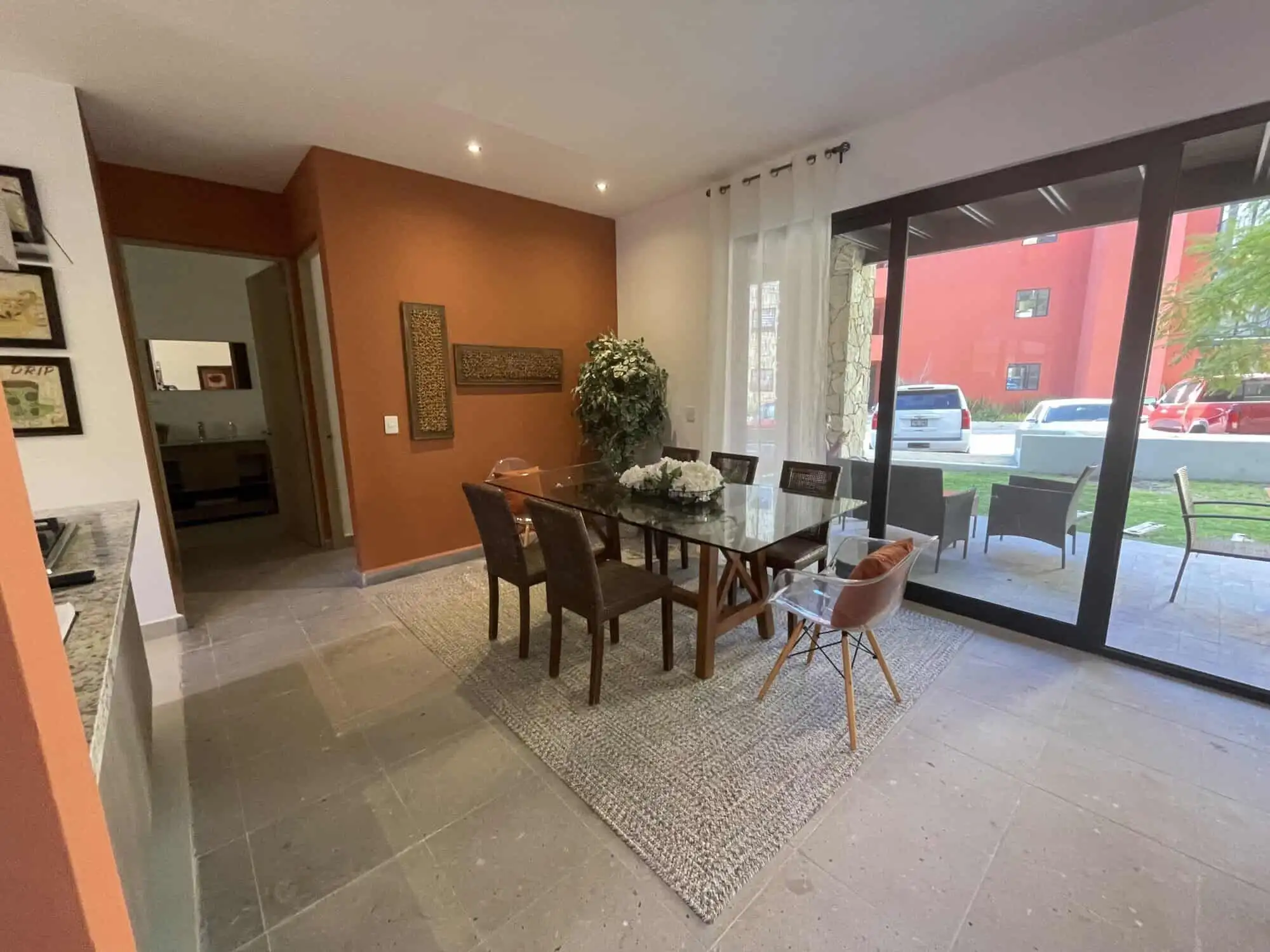 Modern dining room with large sliding glass doors in Punta del Cielo. Spacious interior featuring a wooden dining table, six chairs, and natural light.