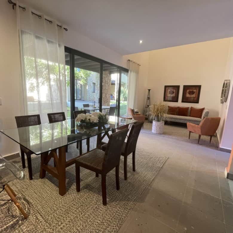 Spacious dining room with glass table, seating for six, and large windows in Punta del Cielo.