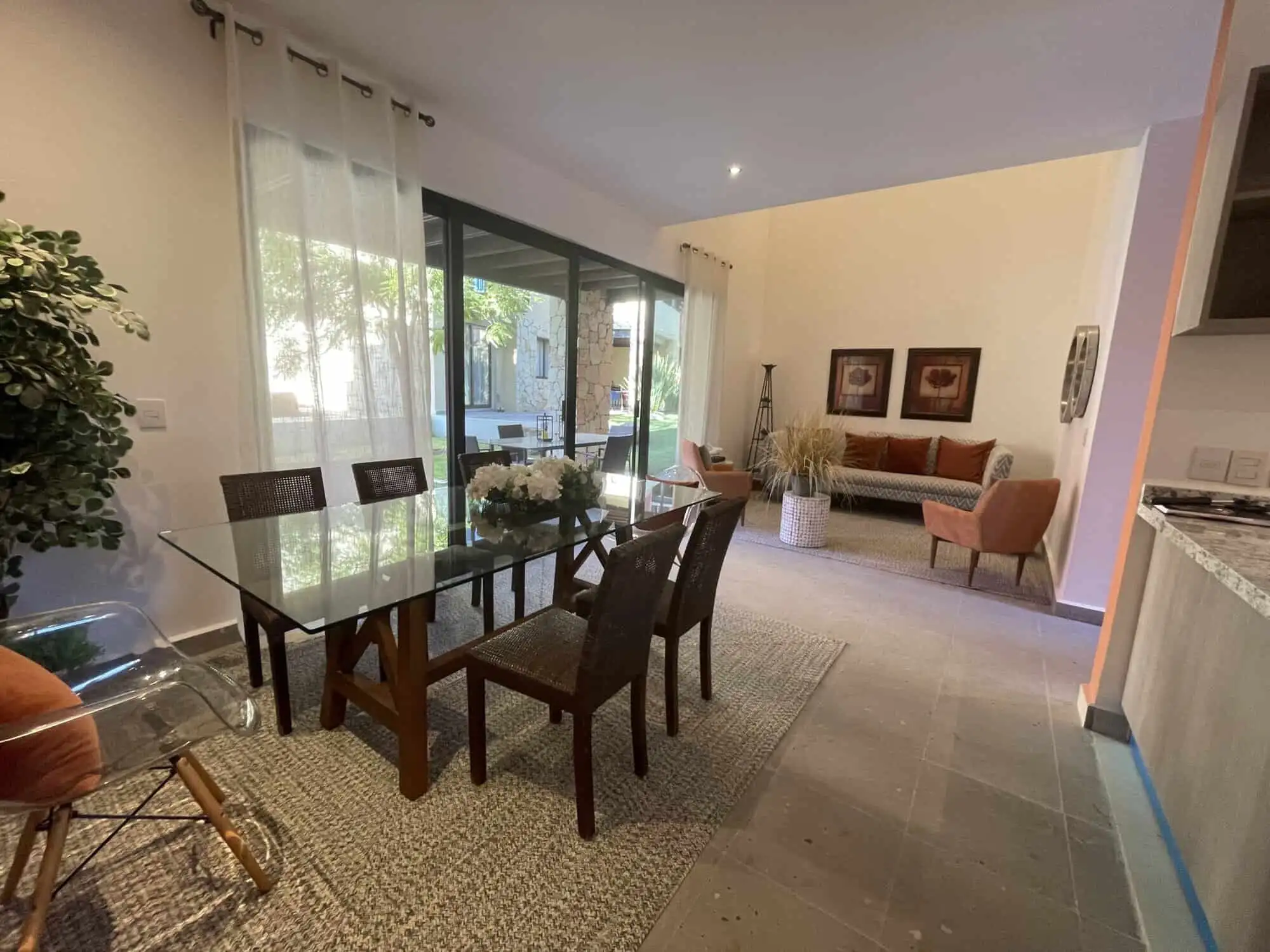 Modern dining area with glass table and stylish chairs in Punta del Cielo home. Spacious dining room with glass table, seating for six, and large windows in Punta del Cielo.