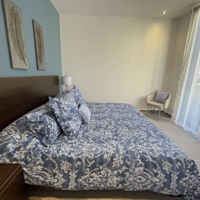 Spacious bedroom with elegant decor and large windows in Punta del Cielo, San Miguel de Allende.