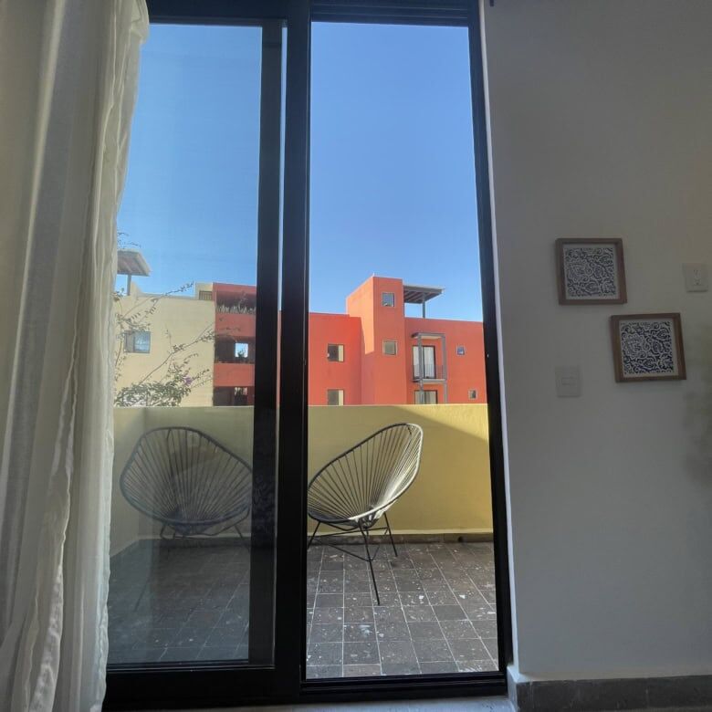 Bright living room with large glass doors opening to a balcony in Punta del Cielo. Modern design and.