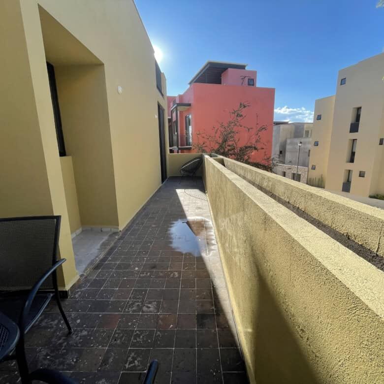 Spacious balcony of a modern Punta del Cielo home with city views and outdoor seating.