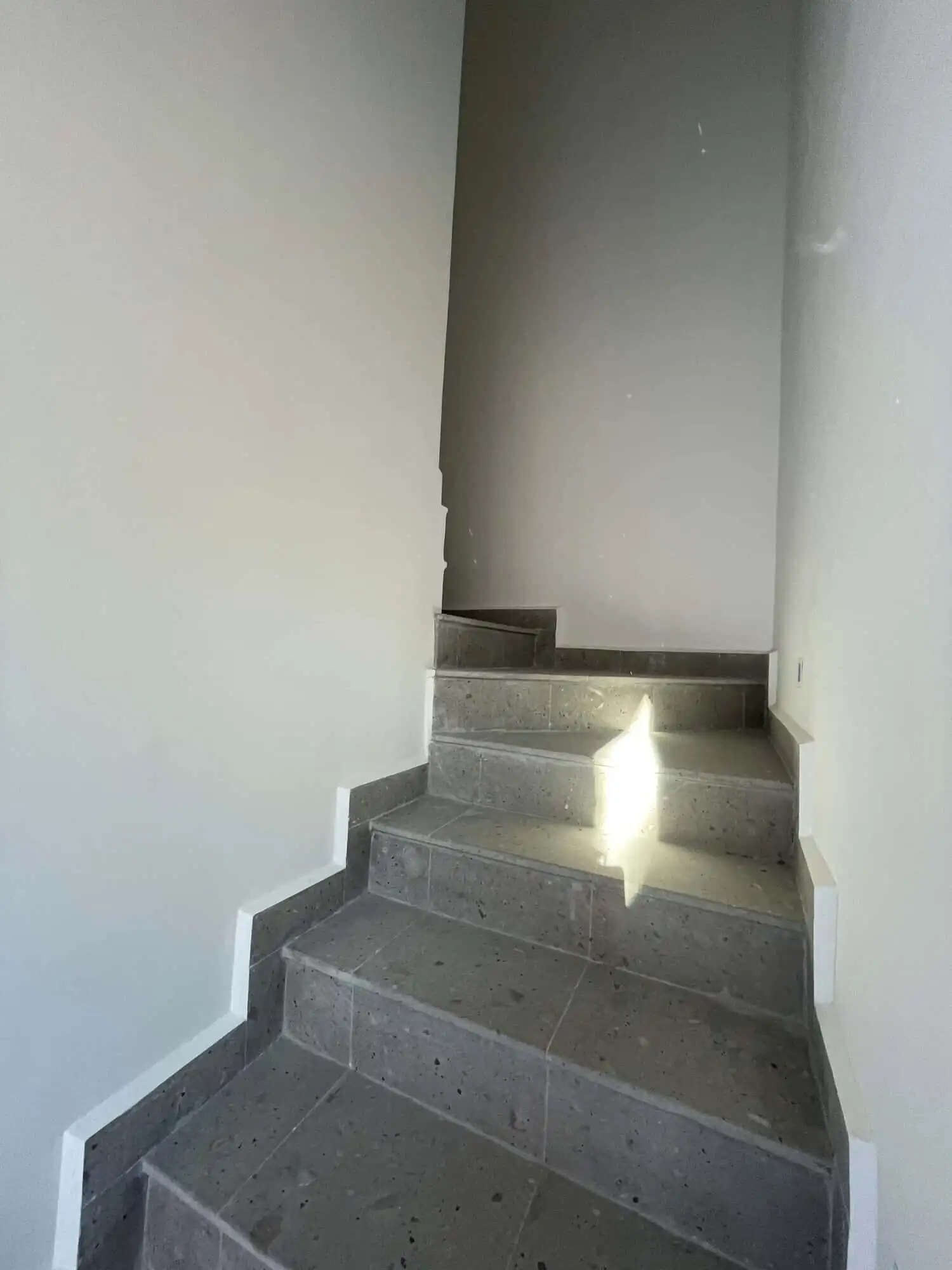 Modern interior staircase in a luxury home in Punta del Cielo. Elegant staircase with gray tiles and white walls in a high-end property.