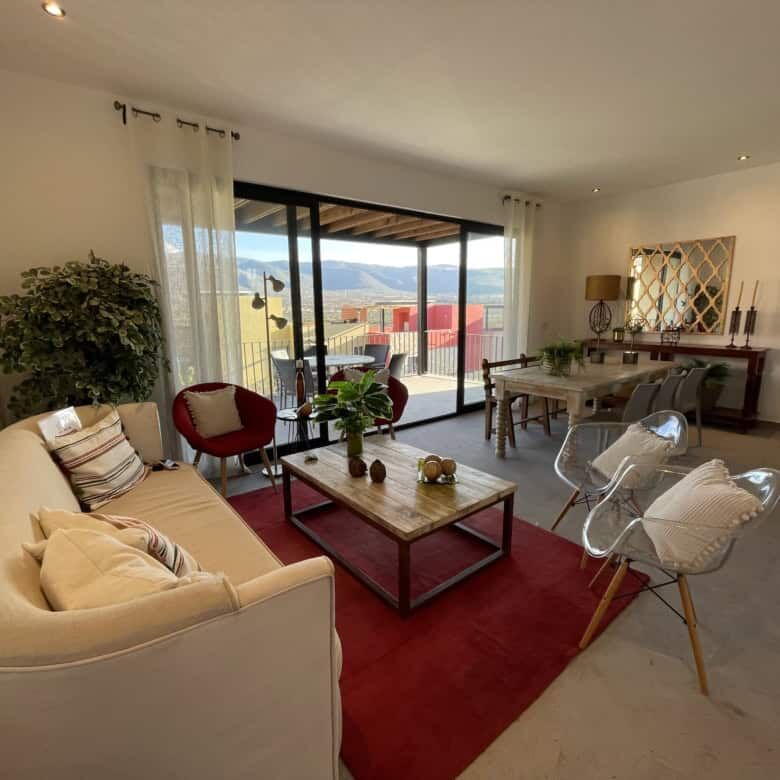Spacious living room with modern decor and large balcony overlooking scenic views.