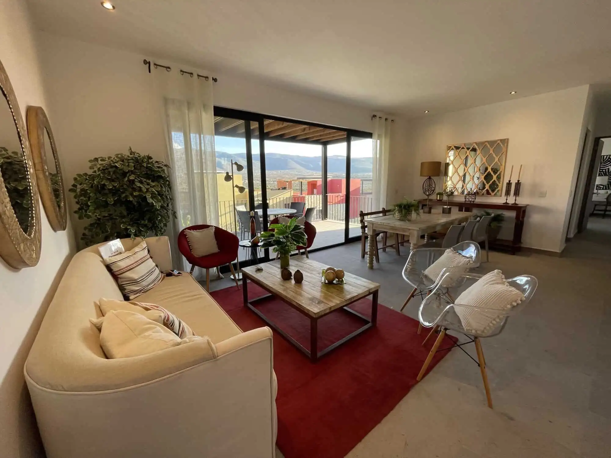 Spacious living room with modern decor and large balcony overlooking scenic views.