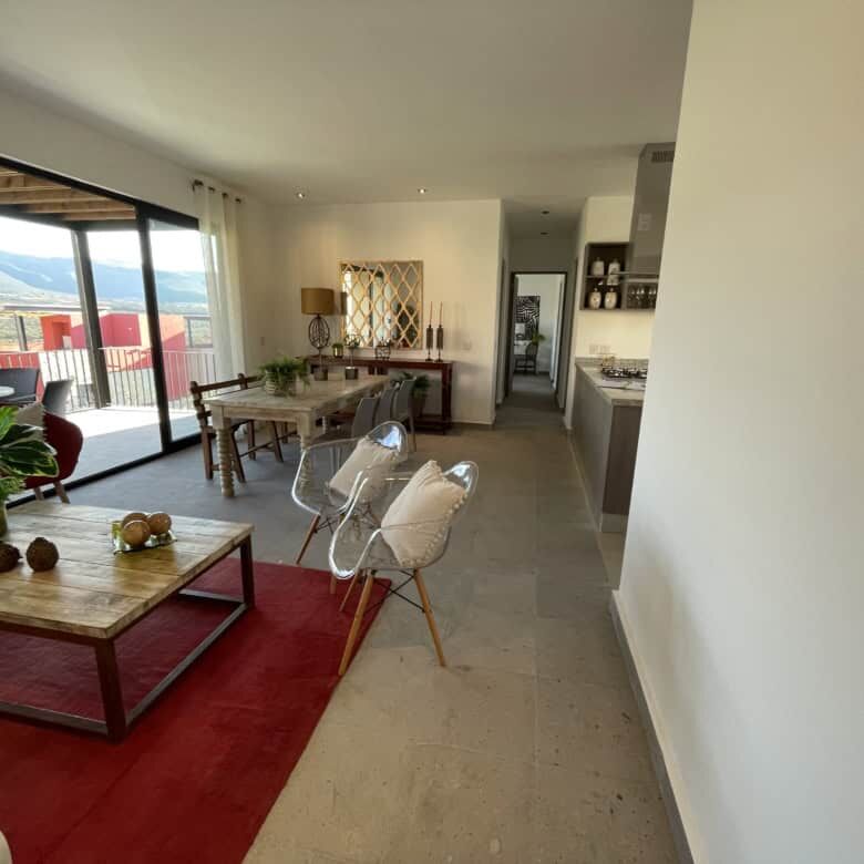 Spacious living area with modern decor and large windows offering city views.
