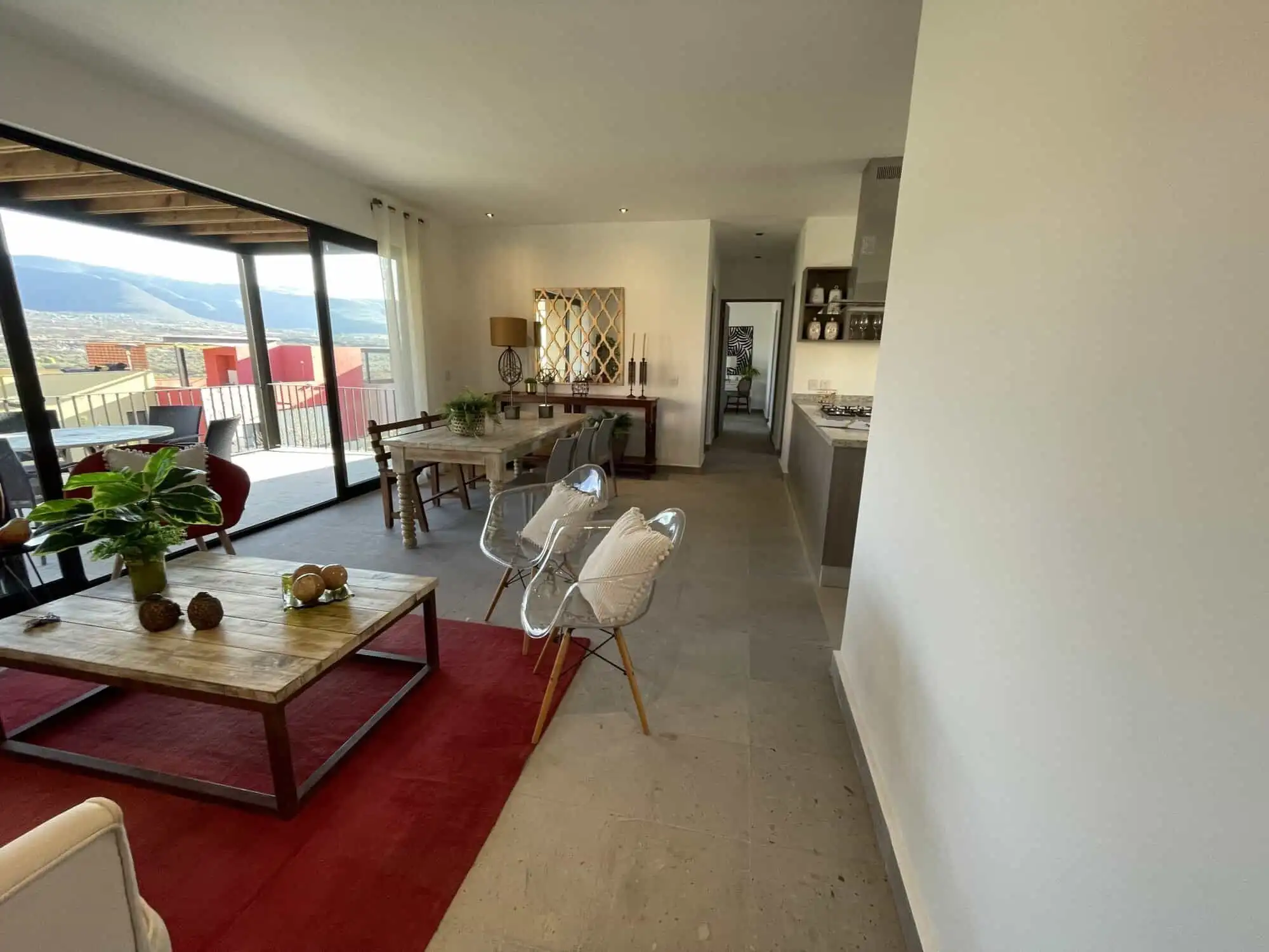 Spacious living area with modern decor and large windows offering city views.