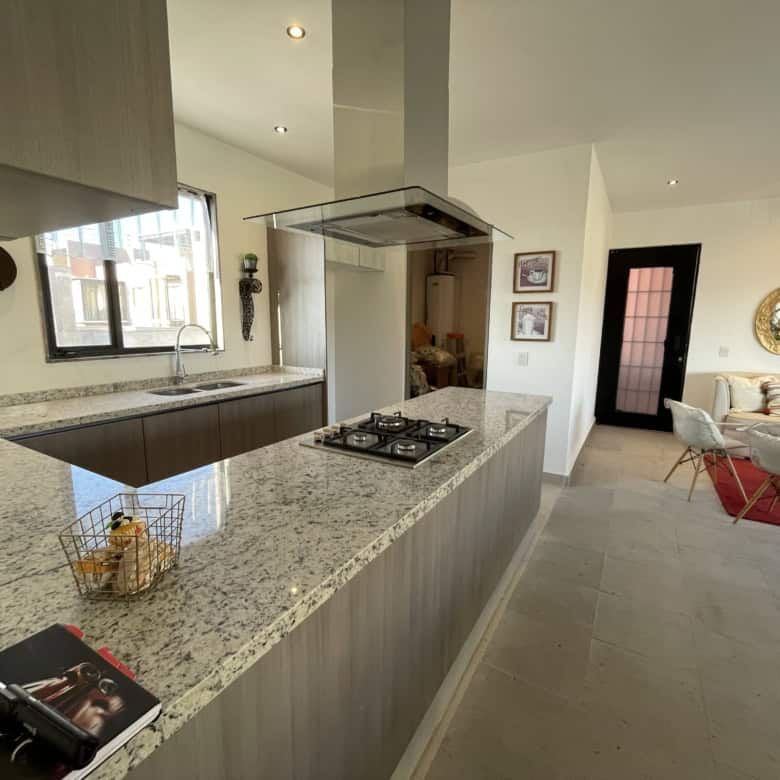 Spacious kitchen with modern appliances and open-plan living area in Punta del Cielo.