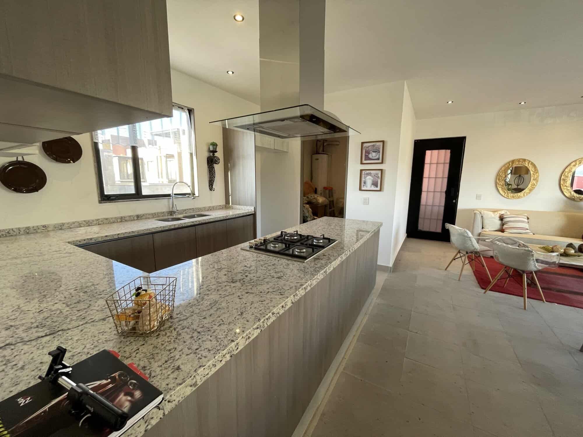 Spacious kitchen with modern appliances and open-plan living area in Punta del Cielo.