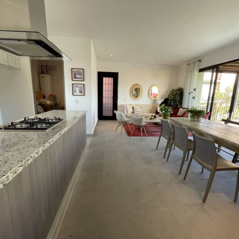 Spacious living area with modern kitchen and large windows offering natural light and scenic views.
