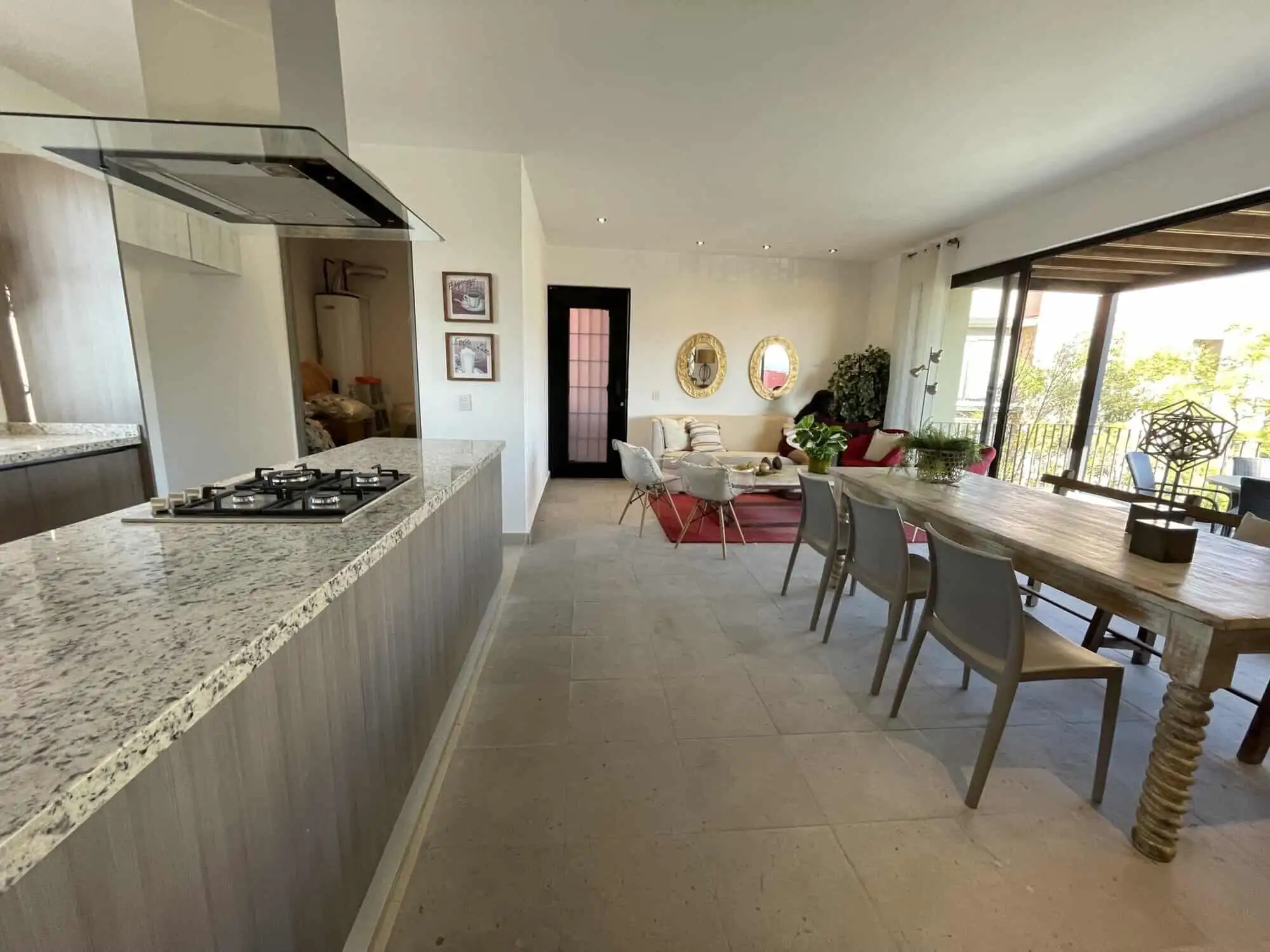 Spacious living area with modern kitchen and large windows offering natural light and scenic views.