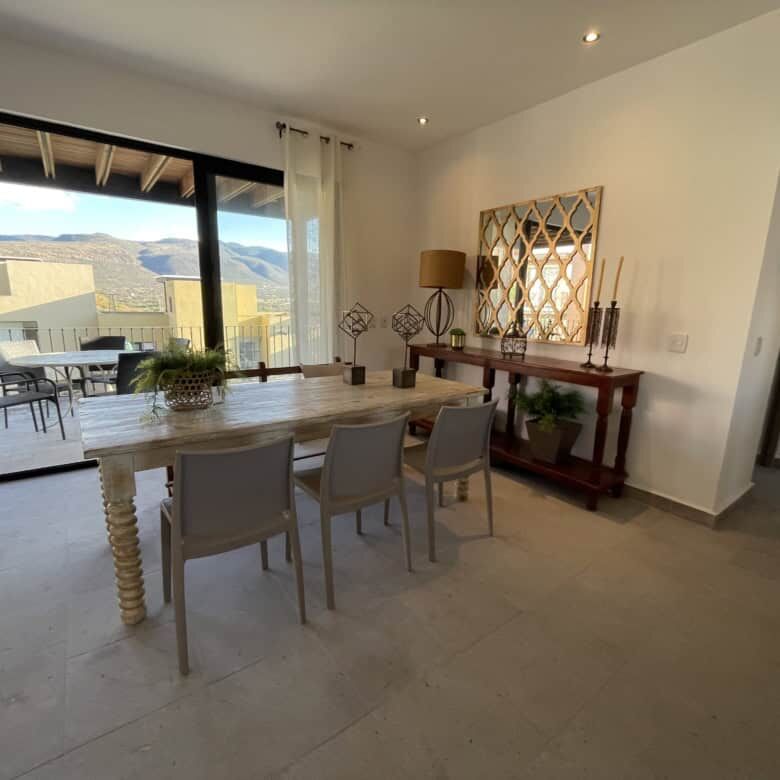Spacious living area with modern decor and large glass doors opening to scenic views.