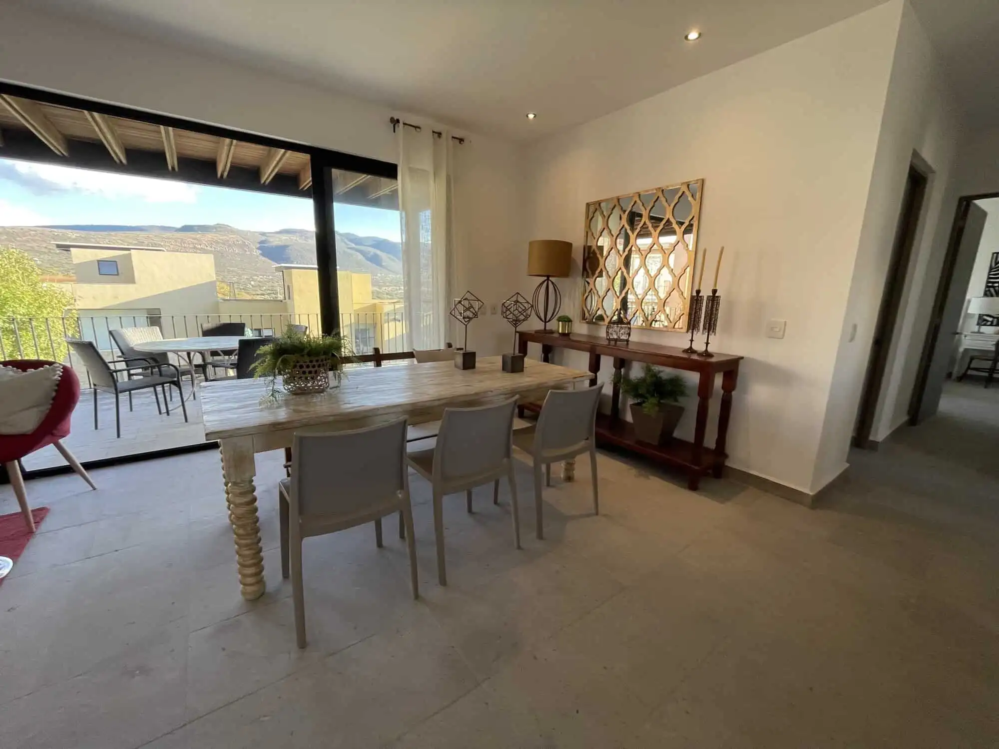 Spacious living area with modern decor and large glass doors opening to scenic views.