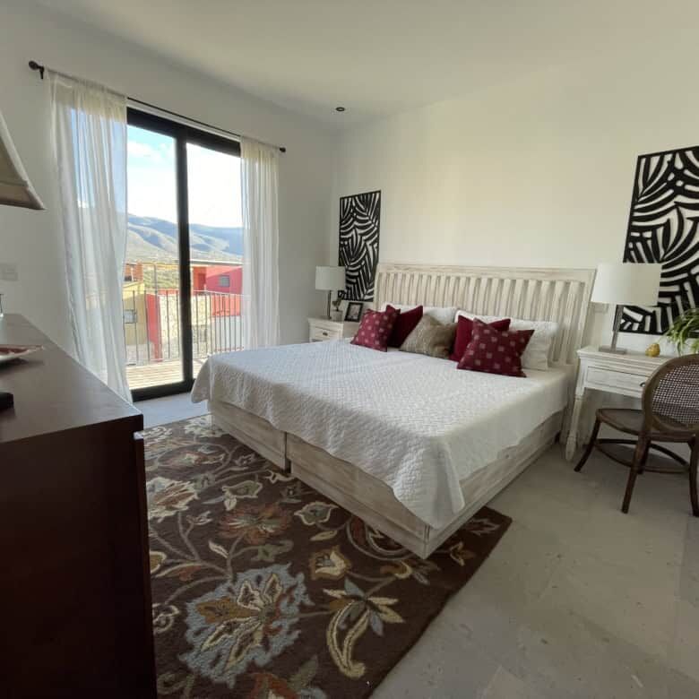 Spacious bedroom with modern decor and balcony views in Punta del Cielo, San Miguel de Allende.