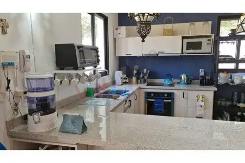 Spacious kitchen with contemporary appliances and stylish decor in a luxury ground-floor condo.