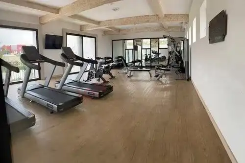 Gym with treadmills, weights, and exercise machines in a bright, spacious room.