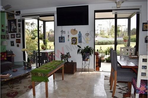 Bright living room with balcony access and large windows, offering natural light and scenic outdoor.