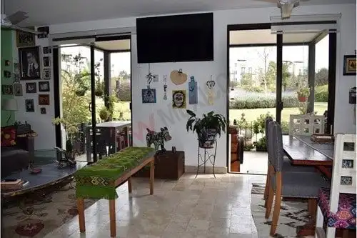 Bright living room with balcony access and large windows, offering natural light and scenic outdoor.