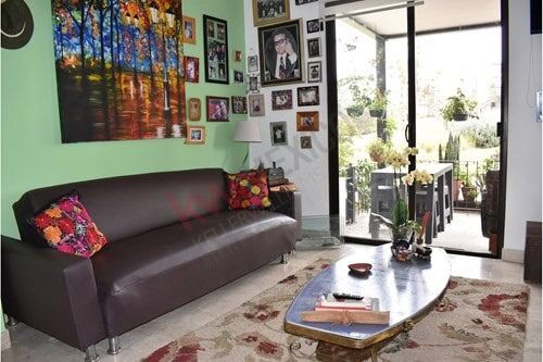 Bright living room with contemporary decor and large glass doors opening to balcony in La Luminaria,.