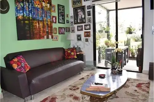 Bright living room with contemporary decor and large glass doors opening to balcony in La Luminaria,.