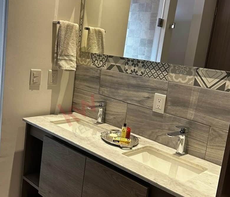 Bathroom vanity with stylish patterned tiles and dual sinks in a contemporary home.