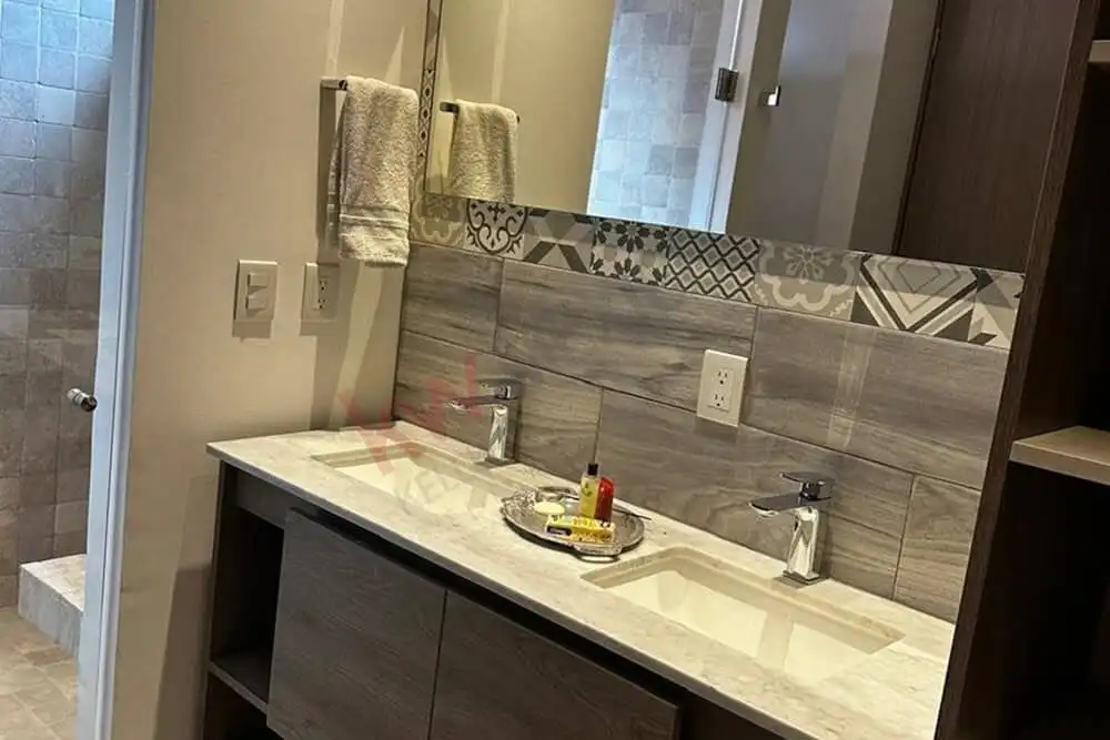 Bathroom vanity with stylish patterned tiles and dual sinks in a contemporary home.