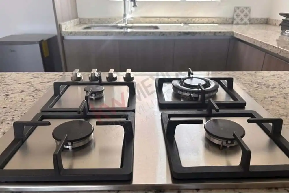 Gas stove with four burners in a modern kitchen for cooking and meal preparation.