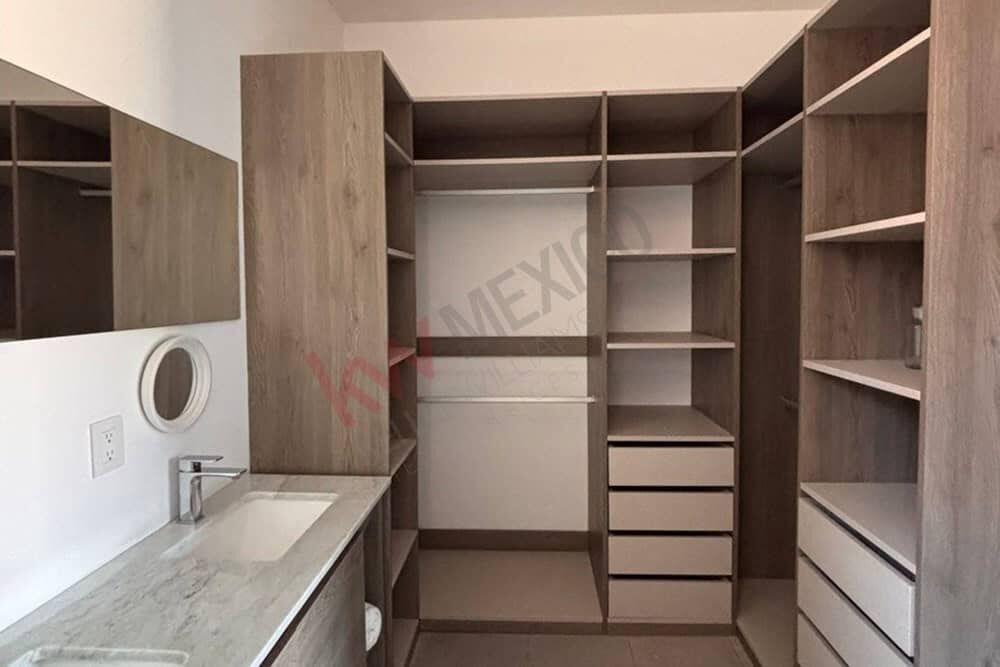 in closet with ample storage space and built-in drawers. In closet featuring organized shelving and drawers for clothing and accessories.