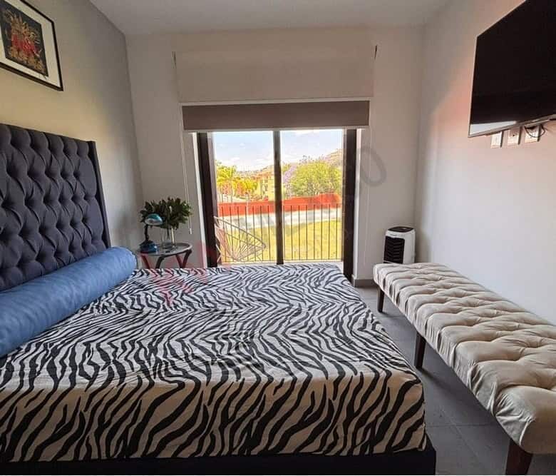 Bright bedroom featuring a large window with scenic Picachos Mountain vistas.