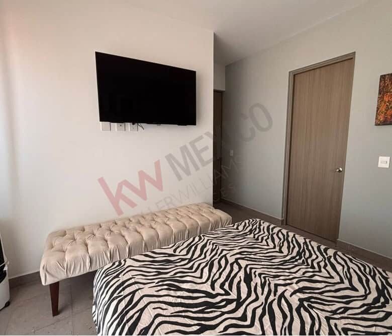 Cozy bedroom featuring a wall-mounted TV, stylish zebra print bedding, and scenic mountain views in.
